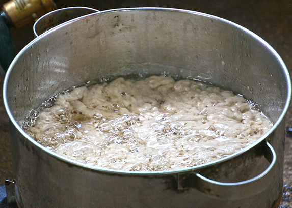 Boiling curdled coconut meat oil at the Polynesian Cultural Center.