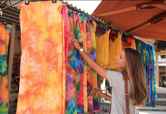 A woman shopping for Tahitian Pareos at the Hukilau Marketplace