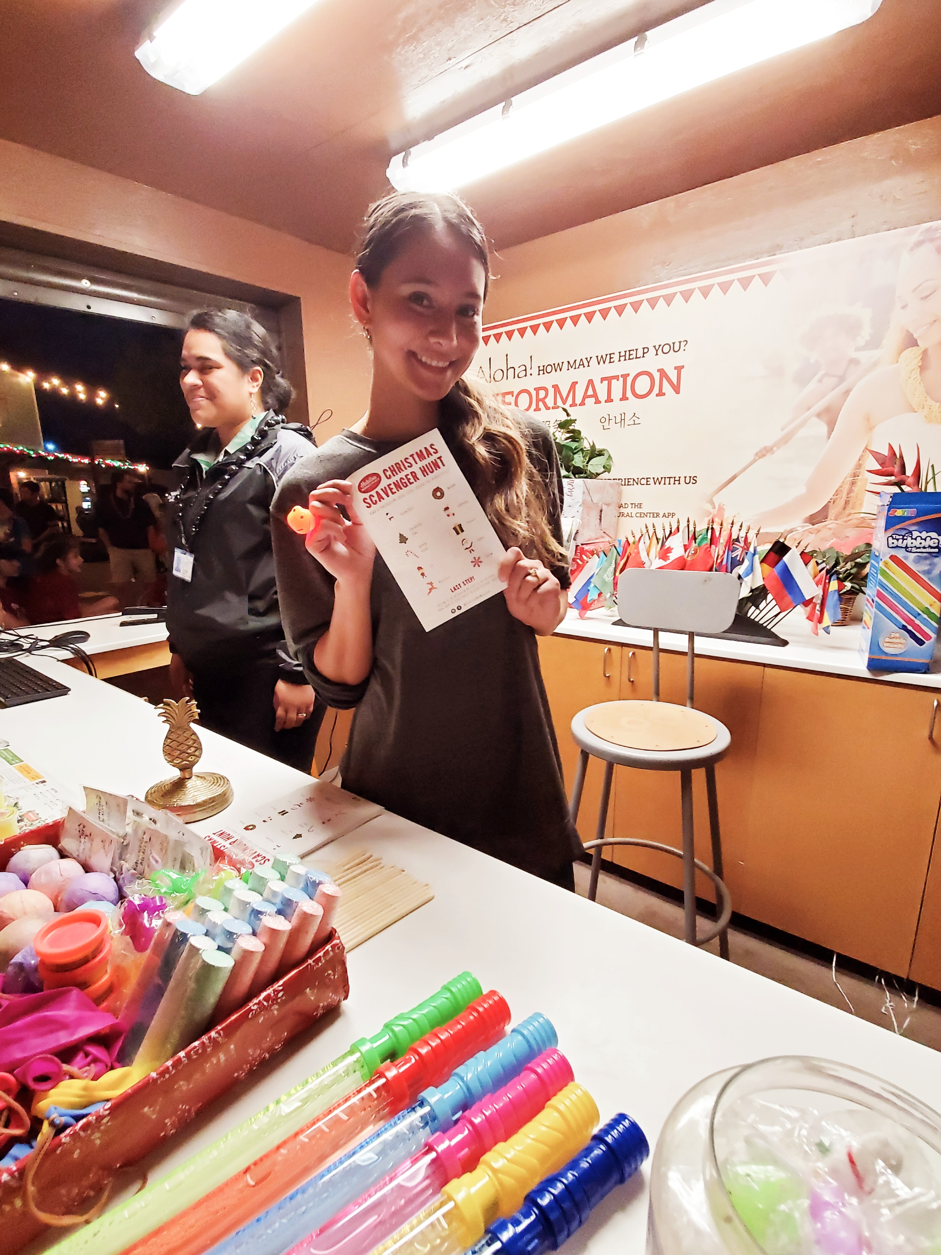 Photo of Whitney Hungerford from the Hukilau Marketplace showing off a Scavenger Hunt list of items to search for.