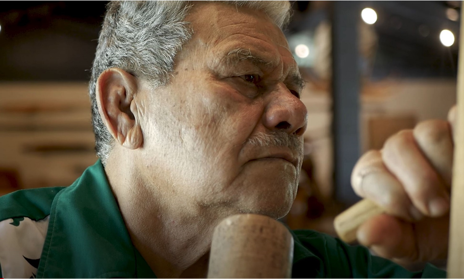 photo showing Tione Puloto working on a piece of art.