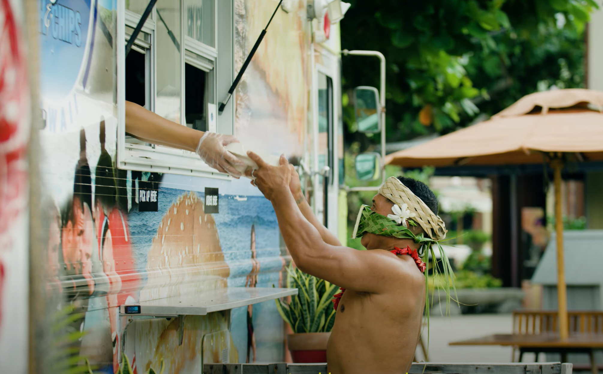 Kap Tafiti poses with food while wearing a mask at the Hukilau Marketplace
