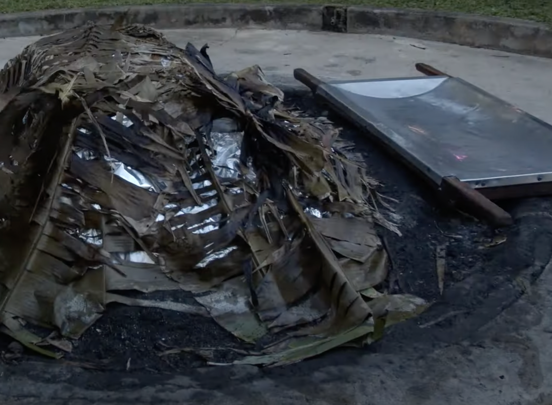 photo of uncovering the imu to get the pig. Method 1: Hawaiian Imu (earth oven)