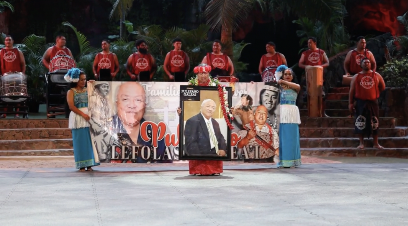Sa Galeai stands in front of her husband’s (Pule Galeai) banner to honor him. Banner is held by his twin granddaughters Aaliyah and Chandae