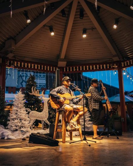 A photo of a Hawaiian local musician performing at the Hukilau Marketplace Christmas celebration.
