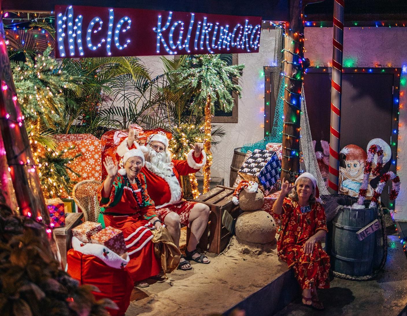 live photograph of Santa Claus, Mrs. Claus, and elf in Hawaiian Christmas theme