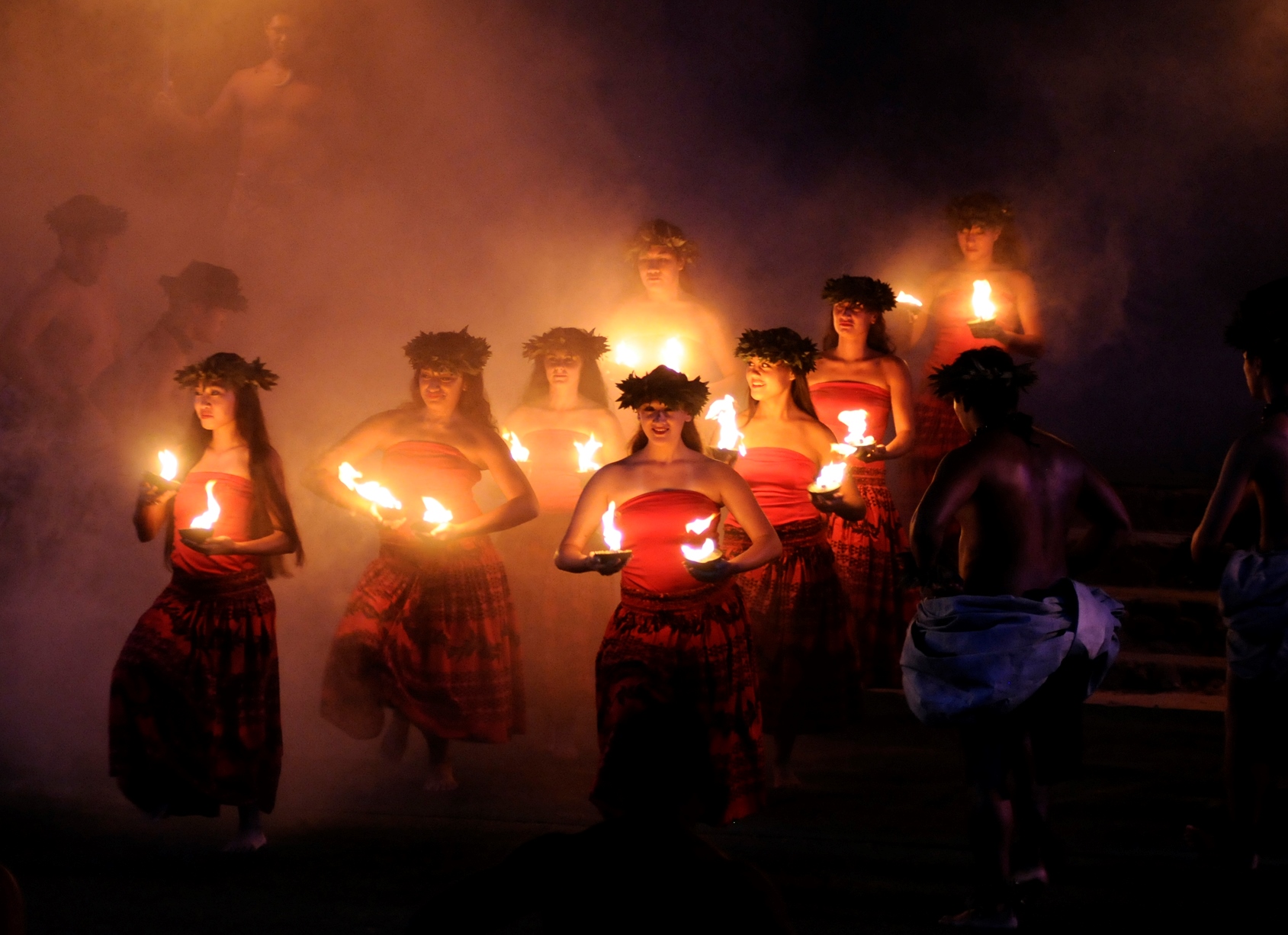 women carrying lighted coconut shells HA Breath of Life